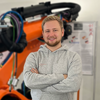 Das Foto zeigt Andreas Zachariae for einem Roboter